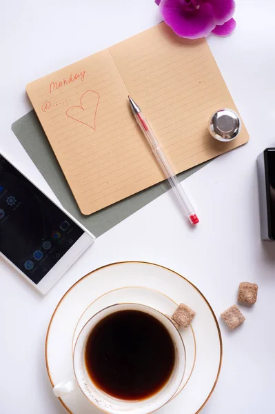 Taza de café con diario y teléfono inteligente alrededor de fondo blanco Fotos de stock