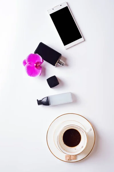 Cup of coffee with smart  phone and lady care set around white b — Stock Photo, Image