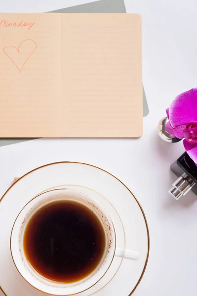 Cup of coffee with diary and perfume around white background. li — Stock Photo, Image