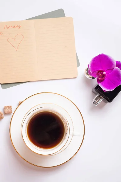 Xícara de café com diário e perfume em torno de fundo branco. li — Fotografia de Stock