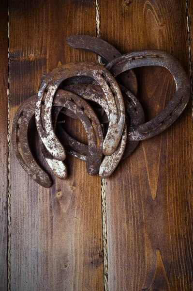 Lucky old  horseshoes laying at wooden floor. — Stock Photo, Image