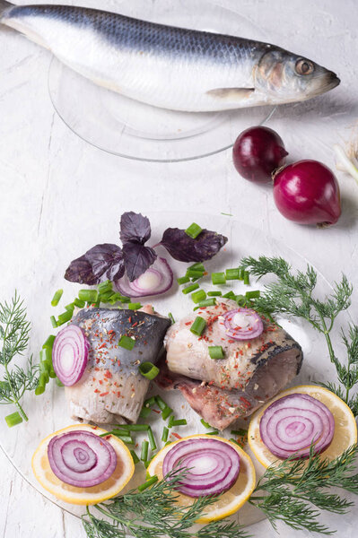 marinated herring roll fillet on a transporant plate with green 