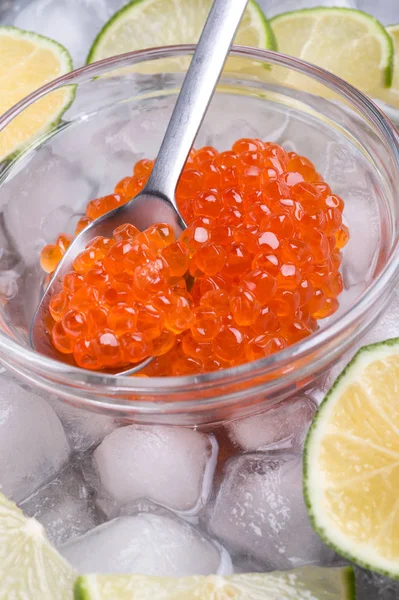 Fechar o caviar de salmão vermelho fresco com colher e limão em torno de ic — Fotografia de Stock