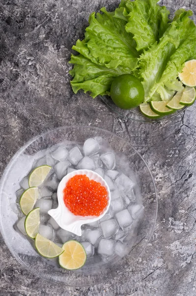 Caviar de saumon rouge frais avec citron vert et laitue autour de la glace. mac. — Photo