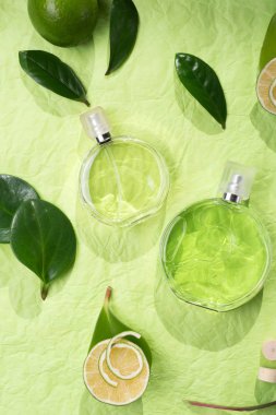  yeşil arka plan üzerinde malzemeler etrafında parfüm şişesi. düz la