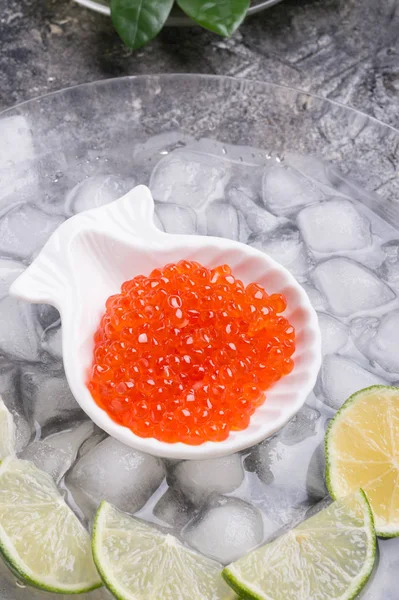 Caviar de salmão vermelho fresco. servido com limão em torno de gelo. macrosh — Fotografia de Stock