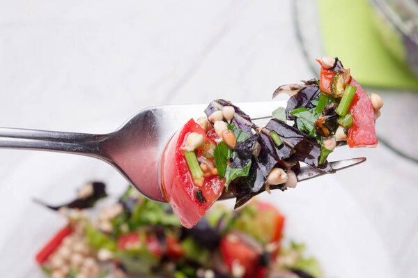 fork with vegetarian fresh salad with vegetables, herbs and  spr