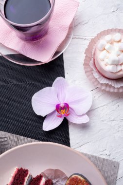 Yaşam tarzı konsepti. Tay mavisi, Kelebek bezelye çayı taze incir ve panna cotta keki ile servis edilen peçete üzerine meyveli kek.. 