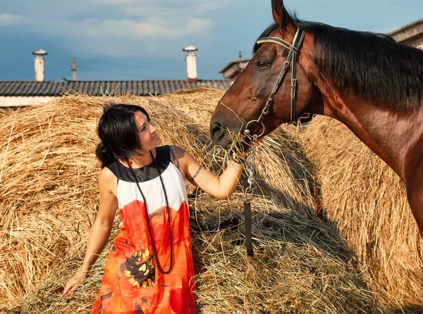 年轻姑娘和她的马靠近干草的肖像 — 图库照片