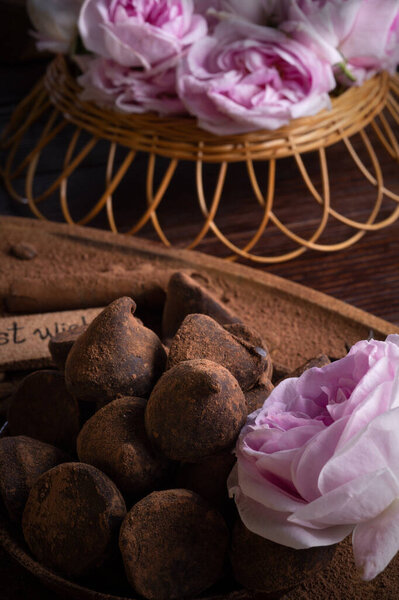  delicious chocolate truffles around ingridients with pink rose bouquet. healthy sweets and present concept. close up