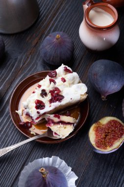 Doğal krema, böğürtlenli kek ve siyah ahşap masada olgun mor incir. Düz yat. yaşam tarzı konsepti