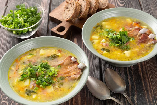 Two plates of delicious yellow split peas soup with smoked pork ribs on a wooden table. — Stock Image Two Plates Delicious Yellow Split Peas Soup Smoked Pork Ribs Royalty Free Stock Photos