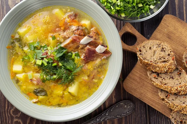 Delicious yellow split peas soup with smoked pork ribs on a wooden table. Top view — Stock Image Delicious Yellow Split Peas Soup Smoked Pork Ribs Wooden Table Royalty Free Stock Images