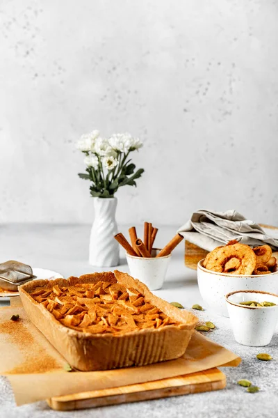 Yulaf ezmesi tabanı ve kurutulmuş elma doldurma ile sağlıklı çiğ Vegan tart, tarçın ile serpilir, seçici odak