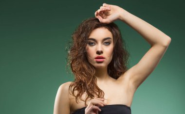 omuz ve şirin makyaj, kahverengi dalgalı saçlı Sevimli Genç kız kamera üzerinde yeşil moda poz arıyorsunuz