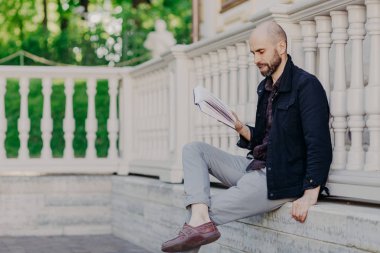 İnsanlar, öğrenme ve eğitim. Sakallı genç erkek öğrenci kitap sınıfları için hazırlanırken himeself gelişir ve özellikle bilgi geliştirir okur küre, pozlar açık tek başına, ciddi