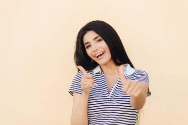 Pozitif esmer erkek onay jest yapar, tutar başparmak, keyfin yerinde olmak yükseltilmiş açık pembe renkli izole bir şey sevinir. İyimser kadın kabul eder ya da yeni proje değerlendirir