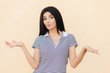 Güzel erkek clueless ifadesi olan, omuz silkiyor, dudaklar yuvarlak tutar, kararsız görünüyor bir yana, içinde rahat kıyafetler giymiş, stüdyo arka plan üzerinde izole. İnsanlar ve belirsizlik kavramı