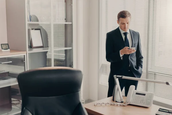 Gutaussehender Junger Männlicher Manager Unternehmenskleidung Surft Mit Dem Smartphone Auf — Stockfoto