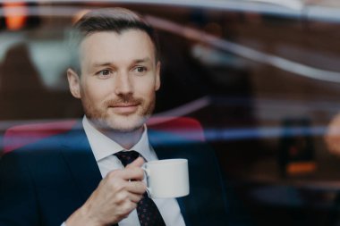 yakışıklı genç işadamı kafede kahve içme takım elbiseli. Eğlence ve iş kavramı 