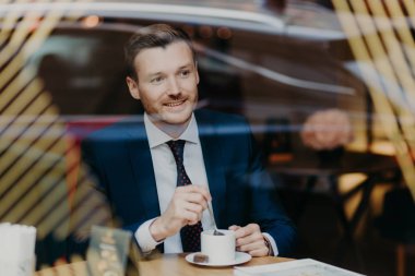 yakışıklı genç işadamı kafede kahve içme takım elbiseli. Eğlence ve iş kavramı 