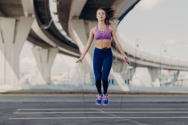 Memnun uygun erkek ile ip atlama egzersizleri, egzersiz daha önce açık ısıtır, sportif gövdeye sahip, mükemmel eğitim vardır. Güzel kız atlar, atletik rakam vardır. İnsanlar, sağlık, spor kavramı