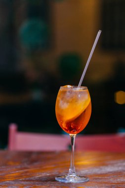 Aperol spiritz kokteyl içerir alkol ve suyu, soğuk buz ve turuncu, tahta masada şarap kadehi tribünlerde restoranda ziyaretçiler için servis