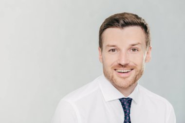 Yakışıklı, tıraşsız vurdu studio neşeli ifade ile erkek girişimci sevinir satış, yükselterek bir yana, metniniz için kopya alanı ile beyaz arka plan üzerinde izole resmi elbise, giymiş