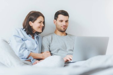 Sevgi kadın ve erkek birlikte sevinç var, dizüstü bilgisayar üzerinde yatak odasında filmi izle, beraberlik keyfini çıkarın ve ücretsiz internet erişimi. Aşık güzel çift yatak odasında iyi eğlenceler