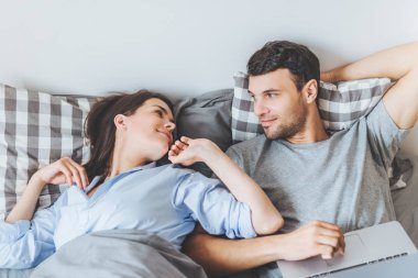 Büyük bir sevgi ile güzel bir kadın bakar kocası, sadece uyanık, dizüstü bilgisayar, birbirimizi mutlu Günaydın ve klavye erkek diyor. Eğlence ve ilişki kavramı