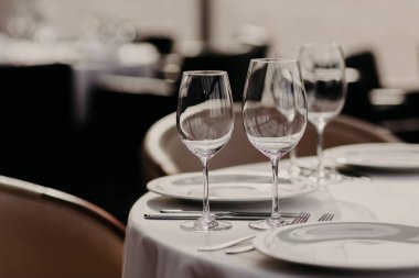 Ziyafet Sofra Restoran İç karşı bir kadeh. Cafe küme. Boş şarap, Gözlük, tabak, çatal ve bıçakları. Yemek için masa hazır. Hiçbir insan resmi