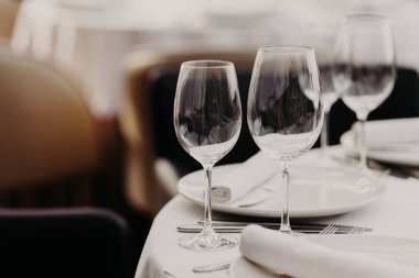 Boş lüks şarap gözlük ve çatal bıçak takımı beyaz bir şekilde dekore edilmiş rahat restoran misafirler için hazır tablo. Ikram Servisi tarafından düzenlenen gıda öğeleri