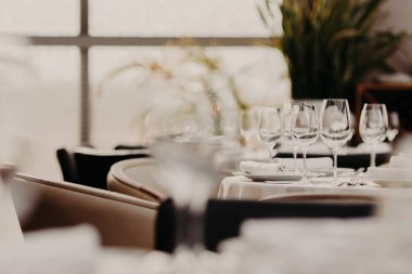 Festival sofra dekore edilmiş lüks yemekler ve arka plan bulanık karşı. Tablo ayarı boş kadehlerin ile. Konuklar için ziyafet salonu