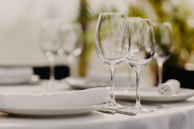 Kutlama ve akşam yemeği kavramı. İki boş tabak ile boş kadehlerin kapalı atış konuklar restoranda görev yaptı. Festival olay. Arka plan bulanık.