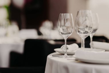 Düğün veya tarafa kadehlerin ve çatal bıçak takımı, beyaz masa örtüsü seti masa. Restoran ziyafet salonu yer ayarında. Kimse ile bayram tablo.