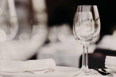 Restoran iç. Ufuk iç. Tablo beyaz masa örtüsü, gözlük ve lüks rahat kafe akşam yemeği için plakalar ile devam eder. Servis ve ikram konsepti