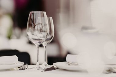 Restoran tablo çatal ve arka plan bulanık karşı şarap bardakları ile devam eder. Konuklar için ziyafet tablo. Festival olay. Rahat bir atmosfer. Cafe et lokantası