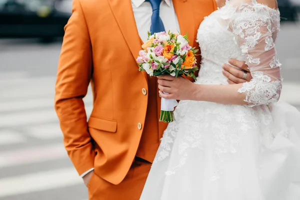 People, love, relationships and wedding ceremony concept. Unrecognizable groom and bride in festive clothes, stand closely and embrace, celebrate creation of their family and marriage, pose outdoor