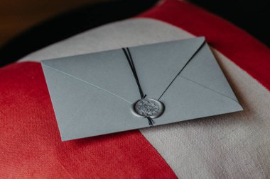 Zarif gri kağıt davetiye kapalı atış kanepe yastık üzerinde yatıyor. Yıldönümü veya düğün için davet. Dekorasyon