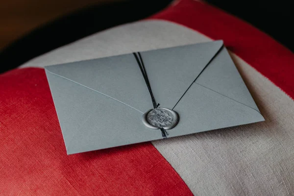 Zarif gri kağıt davetiye kapalı atış kanepe yastık üzerinde yatıyor. Yıldönümü veya düğün için davet. Dekorasyon