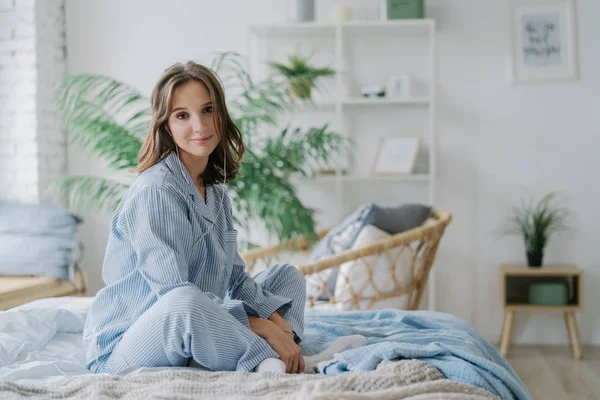 Horizontal Shot Pretty Woman Sits Lotus Pose Bed Dressed Casual — Stock Photo, Image