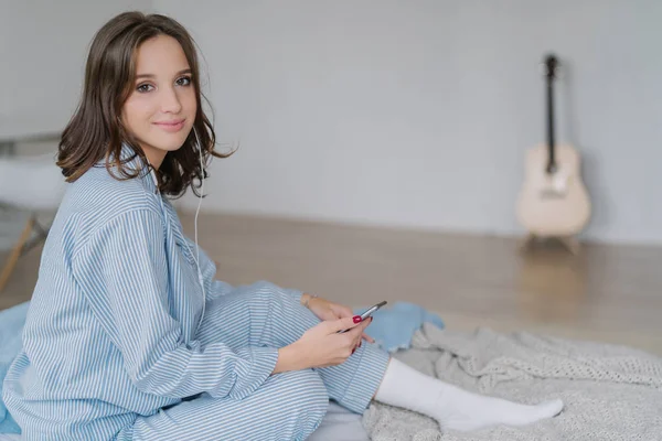 Photo Pleased Relaxed Woman Dressed Casual Clothes Sits Comfortable Bed — Stock Photo, Image