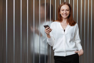 Güzel kadın iş işçisi kurumsal elbise, hücre telefon, online banka app üzerinden transferler para giymiş rexts kablosuz internet'e bağlı mektup, e-posta. Online iletişim.