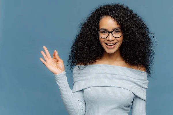 Lysande idé! Glad mörkt flådd ung kvinnlig gör okej gest, ler brett, godkänner somebodys förslag, klädd i blå Jumper, isolerad på blå bakgrund. Kroppsspråk koncept — Stockfoto