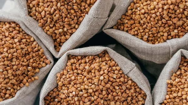 Food and healthy eating concept. Close up shot of raw buckwheat in sacks. Nurture. Dry healthy cereals. Food ingredients. Top view — Stock Photo, Image