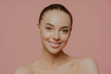 Makyajlı, taze tenli, cildine önem veren, nazikçe gülümseyen ve doğrudan kameraya bakan genç ve güzel bir manken. Kozmetik, kaplıca, yüz tedavisi kavramı