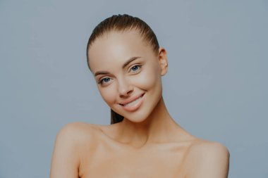 Güzel, kadınsı bir kadın şehvetli ve rahat bakar, güzellik ve tenle ilgilenir, başını eğip çıplak omuzlarını kaldırır, spa ameliyatlarından sonra kendini harika hisseder. Şefkat ve kozmetoloji.