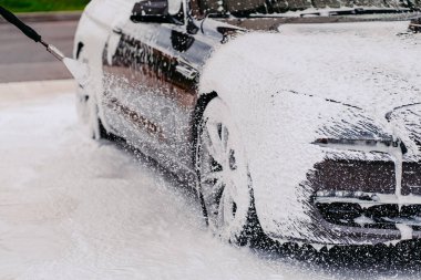 Siyah araba yıkama. Köpüklü otomobil temizliği. Nakliye temizlik konsepti. İstasyonda araba yıkama. Temizlik servisi