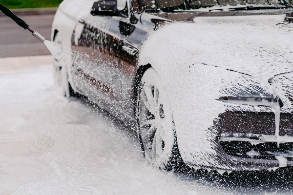 Siyah araba yıkama. Köpüklü otomobil temizliği. Nakliye temizlik konsepti. İstasyonda araba yıkama. Temizlik servisi