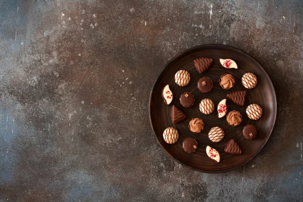 Chocolaatjes Een Kleiplaat Grunge Stenen Achtergrond Bovenaanzicht Kopiëren Van Ruimte — Stockfoto